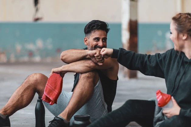 Fitte Trainingspartner sitzen auf dem Boden
