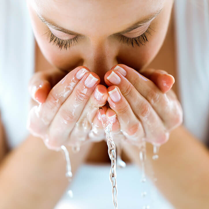 Frau wäscht sich das Gesicht mit Wasser | Doppelherz