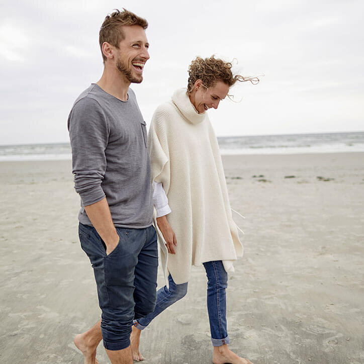 Glückliches Paar beim Spazierengehen am Strand | Doppelherz