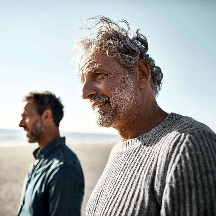 Zwei lachende Männer am Strand | Doppelherz
