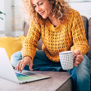 Frau recherchiert an ihrem Laptop zu Vitamin B12 Tabletten.