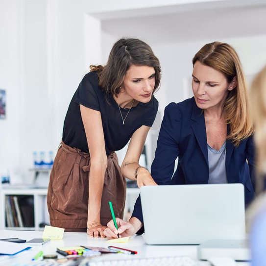 Drei Geschäftsfrauen arbeiten am Schreibtisch im Büro 