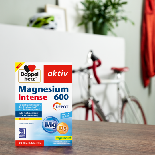Doppelherz Magnesium 600 Intense auf Tisch mit Fahrrad im Hintergrund