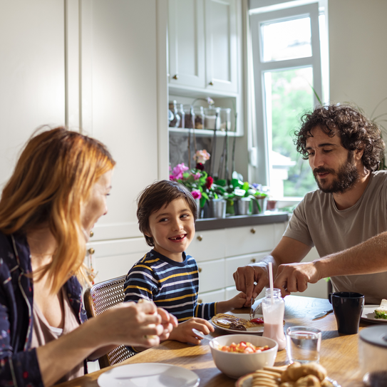 Familie sitzt am Frühstückstisch