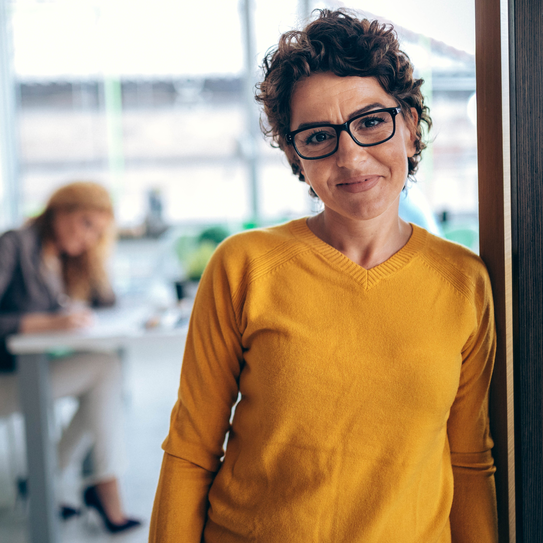 Frau mit Brille lächelt in die Kamera