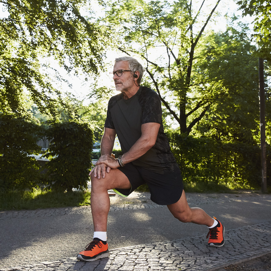 Älterer aktiver Mann dehnt sich beim Sport