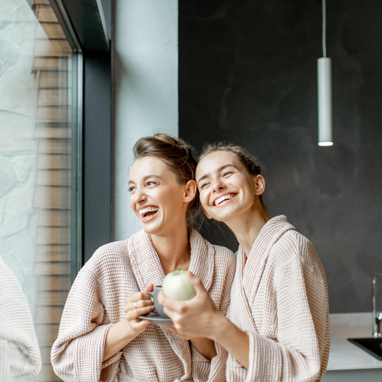 Junge lachende Frauen im Bademantel