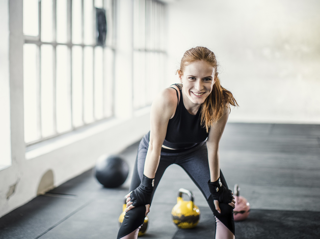 Sportliche Frau nach dem Sport im Fitnessraum.