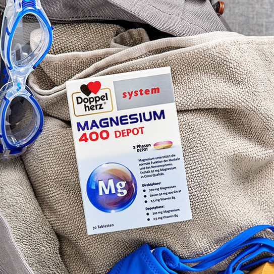 Doppelherz system Magnesium 400 Depot auf Handtuch mit Schwimmbrille
