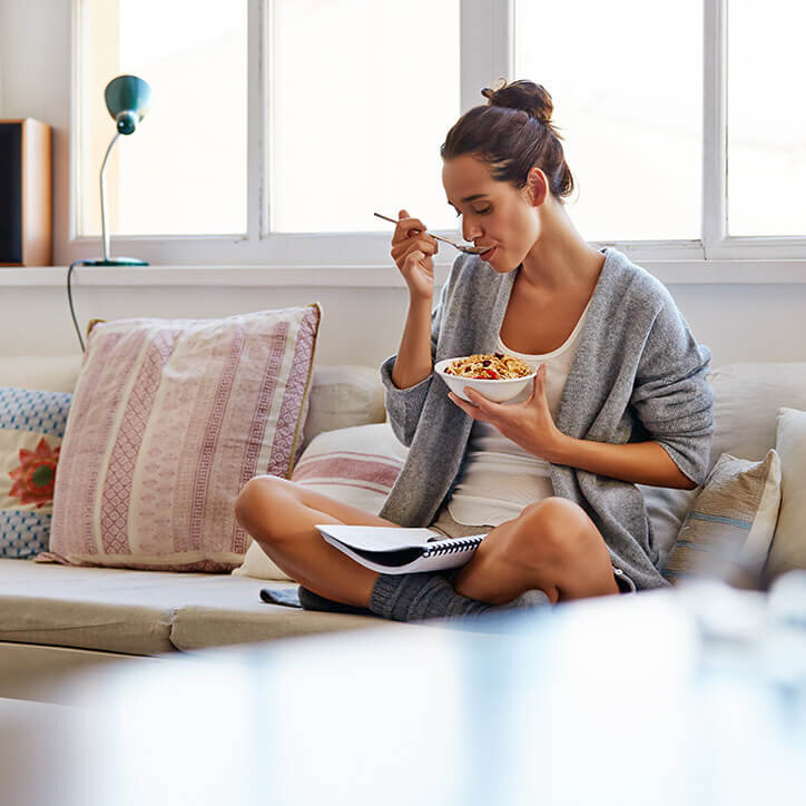 Frau frühstückt auf Sofa | Doppelherz