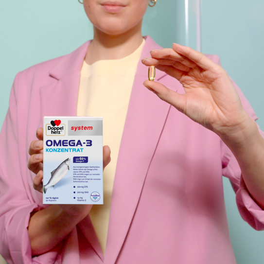 Frau hält Doppelherz system omega-3-konzentrat Produkt in der Hand